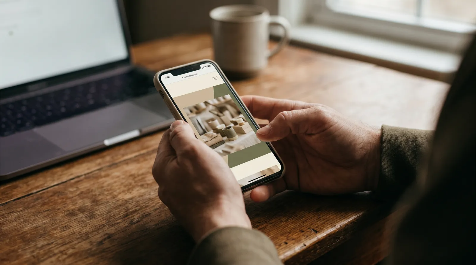 Hände halten ein Smartphone mit einer modernen Unternehmens-Webseite