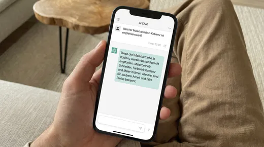 Smartphone, auf dem ein KI-Assistent auf die Frage nach einem Betrieb drei lokale Anbieter empfiehlt