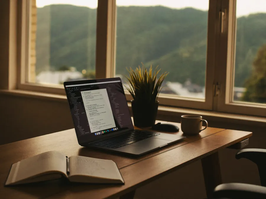 Schreibtisch mit Laptop und Blick ins Rheintal