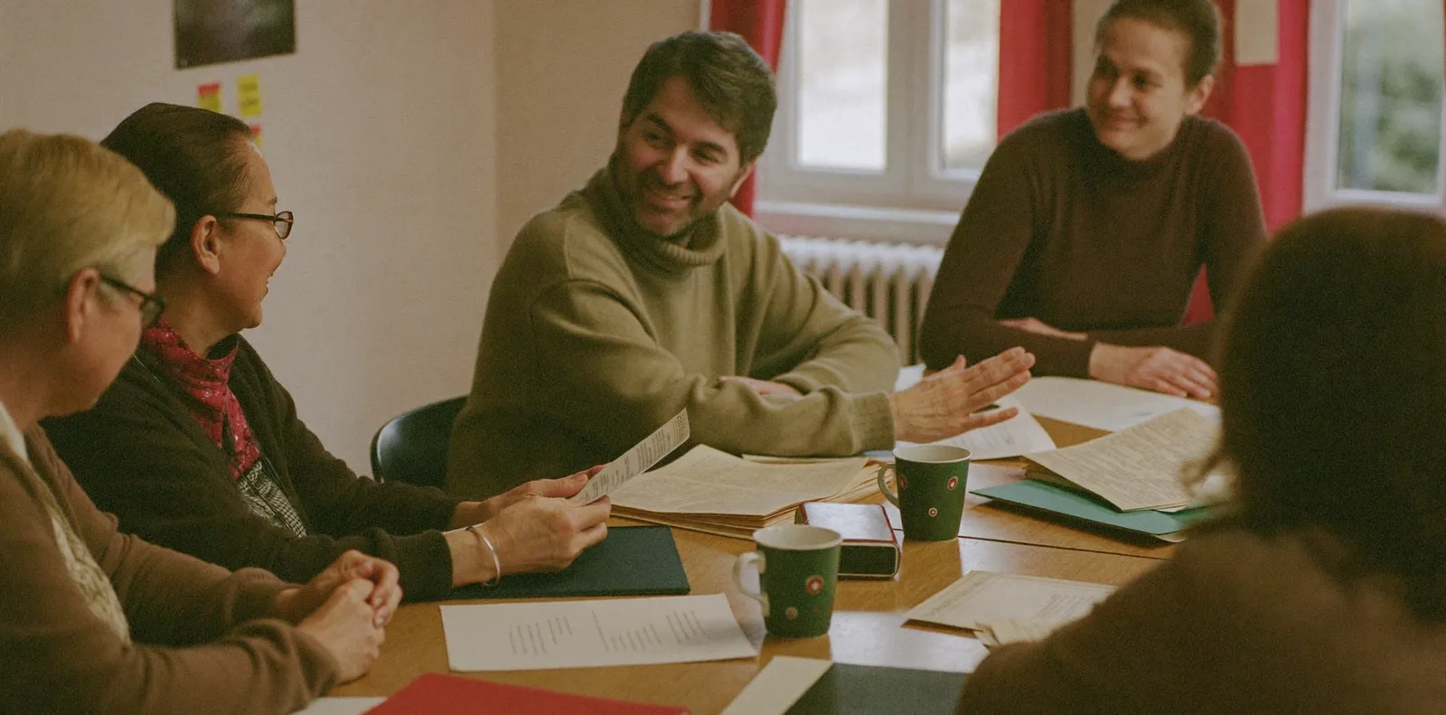 Vereinsmitglieder verschiedenen Alters sitzen am Tisch und planen gemeinsam