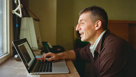 Ladenbesitzerin hinter der Theke schaut nachdenklich auf ihr Smartphone